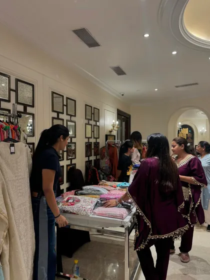 A clothing stall with racks of apparel attracts a group of shoppers looking for new additions to their wardrobe.