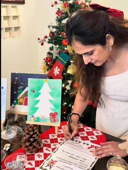Even I get into the festive spirit. Here I am at the 'Letter to Santa' station, surrounded by beautiful kid-made paintings and a decorated Christmas tree.