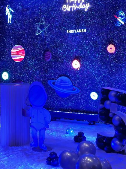 Another angle of the holographic space theme, showing the astronaut, planets, and a large light-up number "5" for the birthday boy.