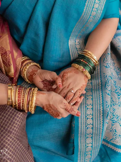 A close-up of two women holding hands, a simple yet powerful image of connection and support at a home wedding.