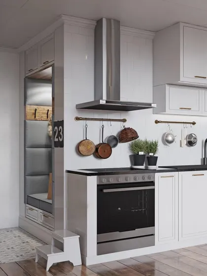 A compact classic kitchen design in white. This layout efficiently uses space with features like hanging pot racks and an integrated bench seating area with storage underneath.