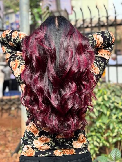 We're obsessed with this wine red hair color. Accessorized with flowers, this look is romantic, bold, and absolutely beautiful.