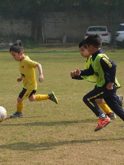 A young player dribbles while being pursued. We are in this together, and that means challenging each other to be better in every drill.