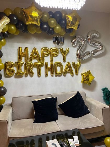 The combination of a balloon arch and foil letters creates a complete and impressive photo backdrop for the celebration.