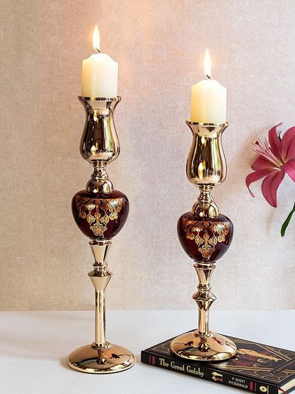 These tall, slender candle stands in a deep red and gold are perfect for creating a romantic ambiance. Their elegant shape and rich colors make them a beautiful addition to a dining table or mantelpiece.