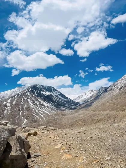 Snow-capped peaks meeting the rugged, barren mountains of Ladakh. This is the dramatic contrast that makes the landscape so unique.