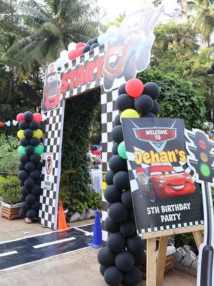 The entrance to Jehan's 5th birthday party, featuring characters from the movie 'Cars' and a custom welcome sign. The racetrack path immediately immerses guests in the theme.