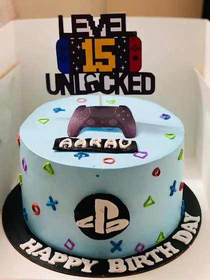 A sleek PlayStation-themed cake for a 15th birthday, celebrating a milestone with a gaming twist.