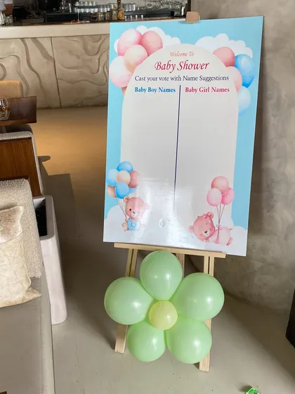 Another fun game for a baby shower, this board invites guests to suggest baby names. The cute design and pastel balloon flower make it a lovely addition to the party decor.