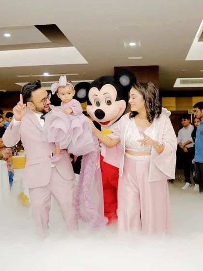 A family poses with the Mickey Mouse mascot amidst a cloud of dry ice, making for a dramatic and fun photo.