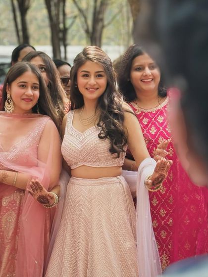 The bride surrounded by her friends and family, looking radiant and happy. Her Haldi look is all about softness and glow.