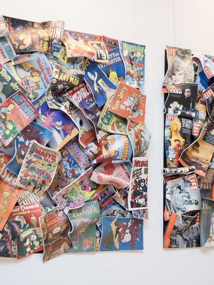 A side view of the "Comic Confluence" and "Chronicles of Life" installations, showing their 3D, layered construction.