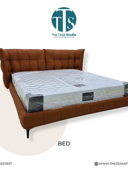 A studio shot of the tan leatherette bed, highlighting its plush, quilted headboard and sleek metal legs.