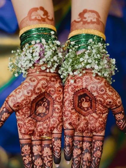 The full view of the swan-themed baby shower mehendi, showing the rich stain and how it pairs with traditional green bangles.