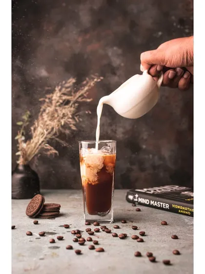 An action shot capturing the moment milk is poured into iced coffee. This dynamic style brings the beverage to life, creating a refreshing and engaging image for a cafe or social media.