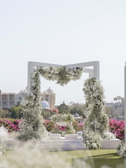The floral mandap arch framing the iconic view of the Udaipur city palace across the lake. This destination wedding design was all about celebrating the beauty of the location.