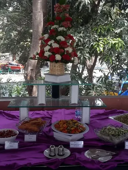 A closer view of our salad and appetizer section from a celebratory event. We use floral arrangements to enhance the beauty of our food displays.