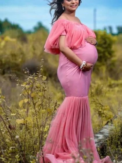 A side profile of the peach mermaid gown, perfectly highlighting the baby bump. This comfortable, stretchy dress is designed to flatter your figure throughout your pregnancy.