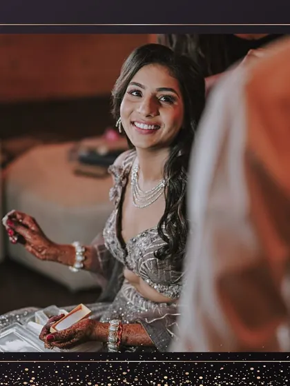 A happy, candid shot during the getting-ready process. Her smile shows her excitement for the Sangeet night, and her makeup is already looking flawless.