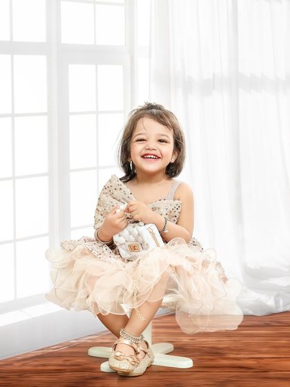 A beautiful, engaging smile. Seated on a simple stool, this little girl's happy face is the star of this classic and timeless portrait.