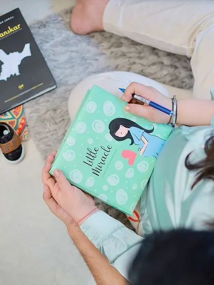 A creative flat-lay style shot, showing the books and baby shoes that are part of the couple's journey. It's all in the details.
