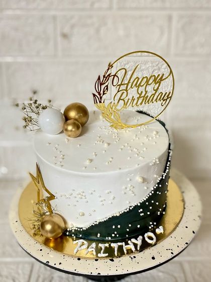 Black or white? Why not both? This striking butterscotch cake features a half-and-half design, accented with gold and white spheres for a modern, elegant look.