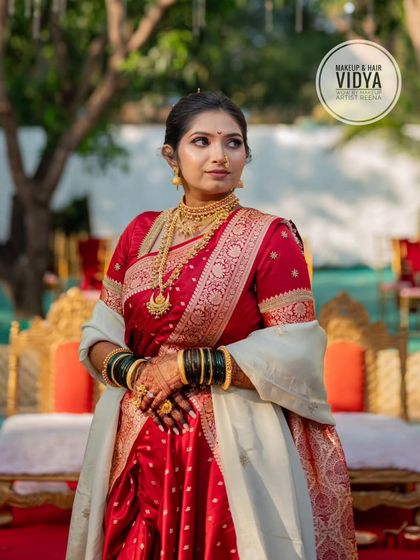 Priya looking regal in her red Nauvari saree, standing on the wedding stage. The full look, from makeup to draping, was done by my artist Vidya.