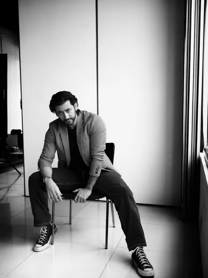 A powerful, full-body pose in black and white. The high-contrast lighting creates a dramatic and masculine look.