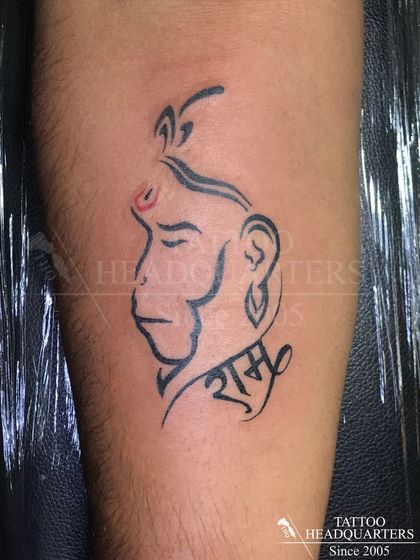 A stylized Hanuman tattoo incorporating the name "Ram" in Hindi script. This design is a tribute to devotion and strength.