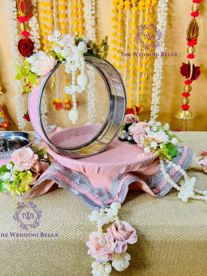 A side view of the pastel pink thali, showing the delicate pearl and floral hangings that add a graceful touch.