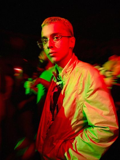 Caught in the lights during a club night. The mix of red and green lighting captures the intense, moody atmosphere I create with my music. This is my natural habitat.