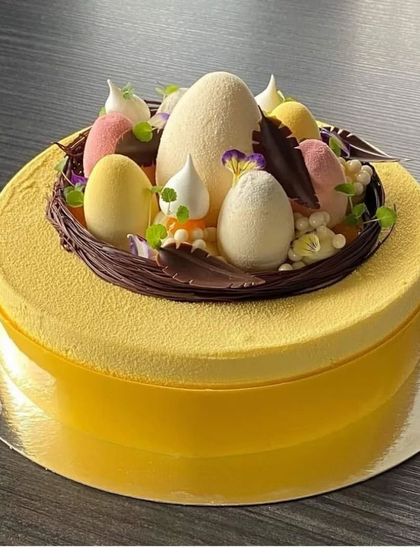 An elegant yellow mousse cake with a nest of chocolate and sugar-spun eggs. This dessert is perfect for an Easter celebration or a spring-themed event.