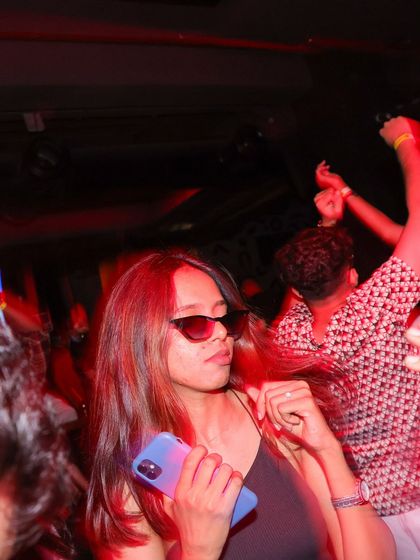 A stylish partygoer enjoying the techno vibes under the red glow at my Sunburn Union event.