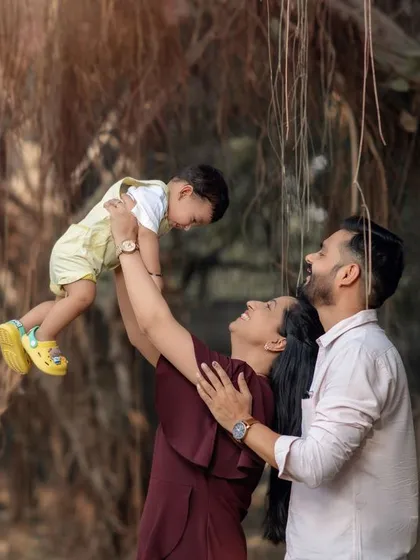 Pure joy as a mother lifts her child into the air during an outdoor family photoshoot. These are the memories that last a lifetime.