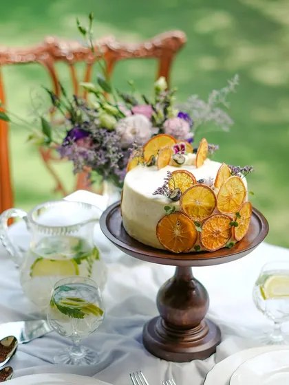 An elegant custom cake, beautifully decorated with dehydrated orange slices and fresh flowers. We create bespoke cakes and dessert tables that serve as a stunning centerpiece for any celebration, from birthdays to weddings.
