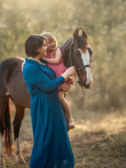 As children grow, the nature of the mother-child bond changes. This portrait with a horse captures a moment of shared adventure and quiet understanding between a mother and her school-aged child.