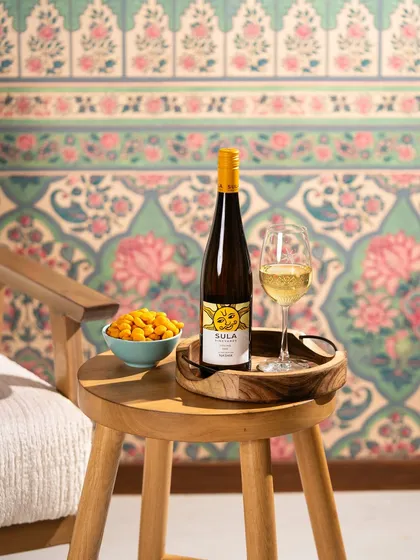 A simple, elegant shot of white wine against a beautiful patterned wallpaper, showing how the product can fit into a stylish home setting.
