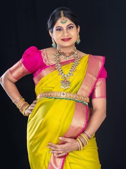 The beautiful Suppi celebrating her pregnancy with a maternity photoshoot. The vibrant yellow and pink saree is paired with a bold lip and glowing skin for a joyful, celebratory look.