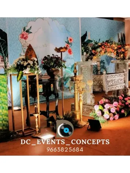 A beautiful traditional cradling ceremony stage. The setup includes ornate brass lamps (diya), a decorated cradle (thottil), and a custom-painted backdrop, blending cultural elements with artistic design.