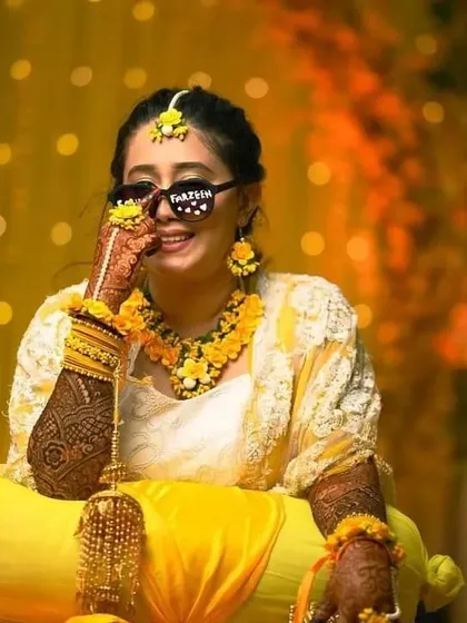 A fun and stylish bride at her haldi ceremony, rocking cool sunglasses and our full-arm bridal mehndi.