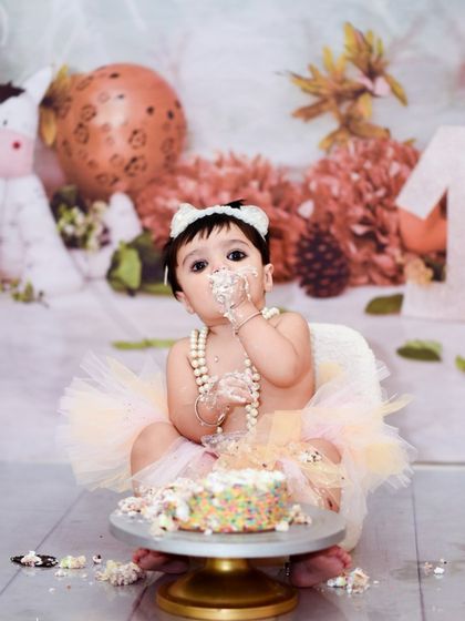 Our cake smash sessions are all about capturing your baby's curiosity and delight. This setup includes a miniature armchair and a globe prop, adding a touch of whimsy to the classic cake smash theme.