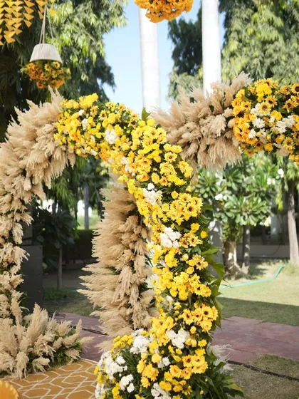 A beautiful floral arch for a Haldi ceremony, crafted with sunflowers and pampas grass. The circular design creates a modern and elegant focal point.
