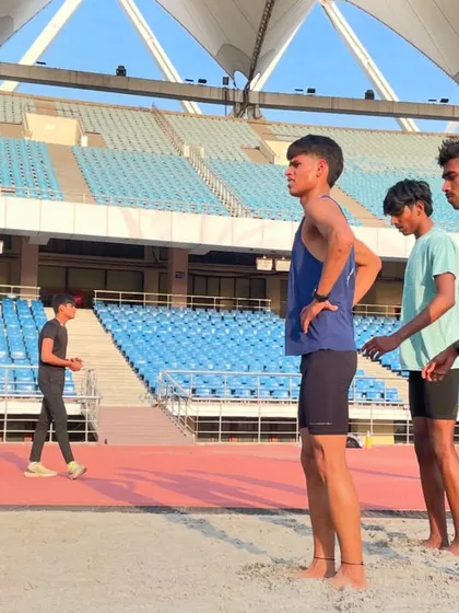 A side view of my athletes in the sand pit, with the impressive JLN stadium in the background. This shows our commitment to using every part of the facility to become better runners.