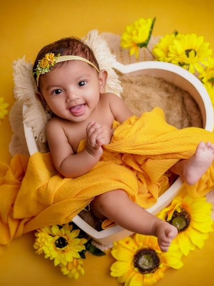A ray of sunshine in my studio. This baby's happy, curious expression is perfectly complemented by the bright yellow sunflowers.