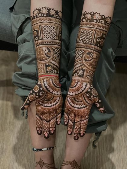 A classic bridal design with peacocks and geometric patterns, extending up the arm for a full bridal look.