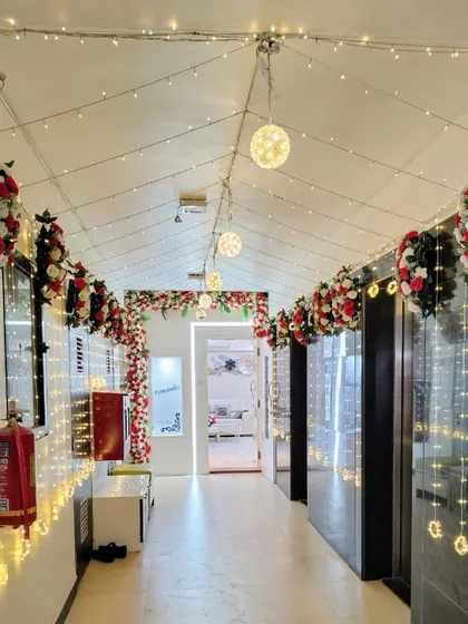 We decorated this entire home lobby to create a festive wedding atmosphere. The ceiling is adorned with fairy lights and floral bouquets of red and white roses, leading guests down a beautifully lit path.