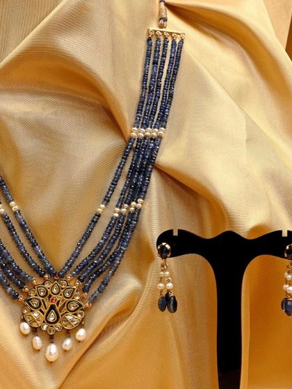 The complete iridescent peacock set, including the double-sided Kundan pendant necklace and matching oval-faceted sapphire eardrops.