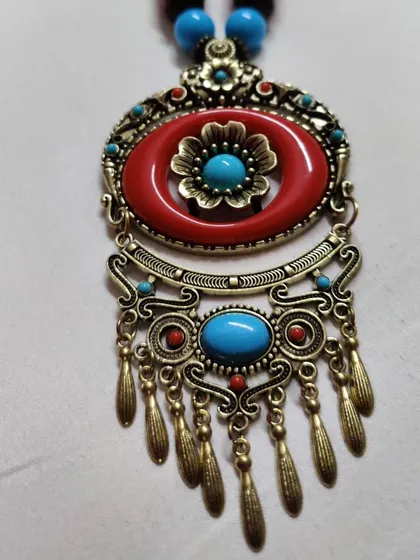 This is a beautiful Turkish-inspired pendant with intricate metalwork and colourful stones. It's a perfect example of the global treasures I find and bring into my collection for you.