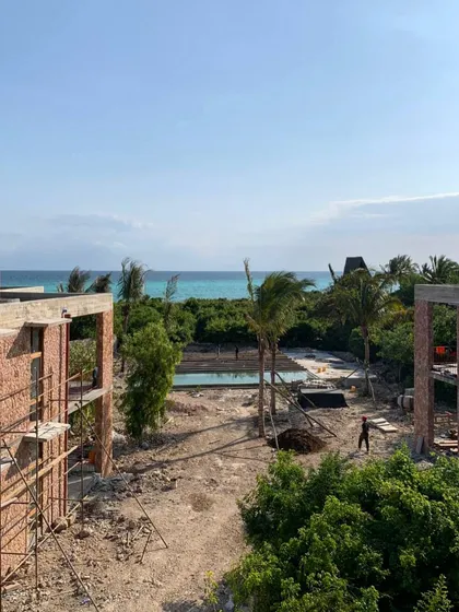 An overview of the phase two construction site at Kizikula, with the ocean in the background. The new buildings are positioned to maximize views and capture the sea breeze, while the pool provides a central gathering space.
