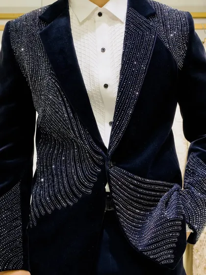 It's all about the details. This close-up shows the precise, handcrafted beadwork on one of our signature velvet reception blazers, designed to catch the light and everyone's attention.